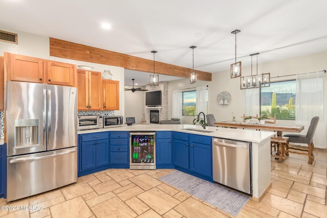 kitchen with light brown cabinets, sink, appliances with stainless steel finishes, beam ceiling, and beverage cooler