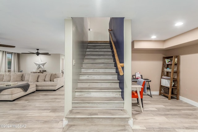 stairs with hardwood / wood-style flooring and ceiling fan