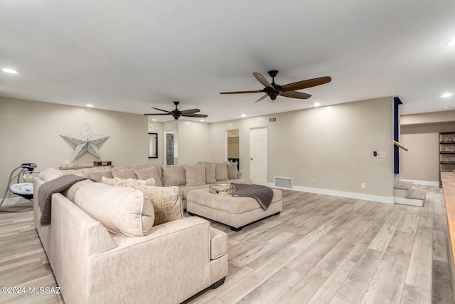 living room with ceiling fan and light hardwood / wood-style flooring