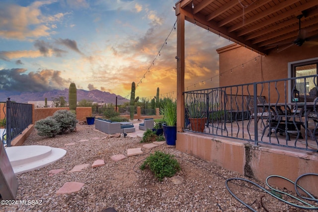 yard at dusk with a mountain view and a patio