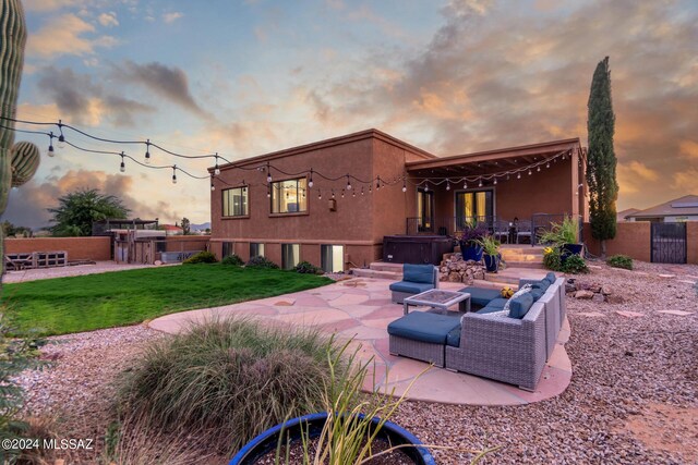 patio terrace at dusk featuring a lawn