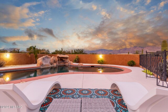 back house at dusk featuring a lawn, a patio area, and an outdoor fire pit