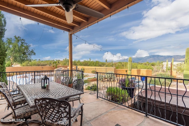 view of patio with ceiling fan and a mountain view