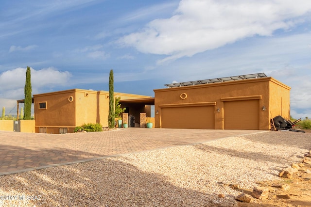 pueblo revival-style home featuring a garage