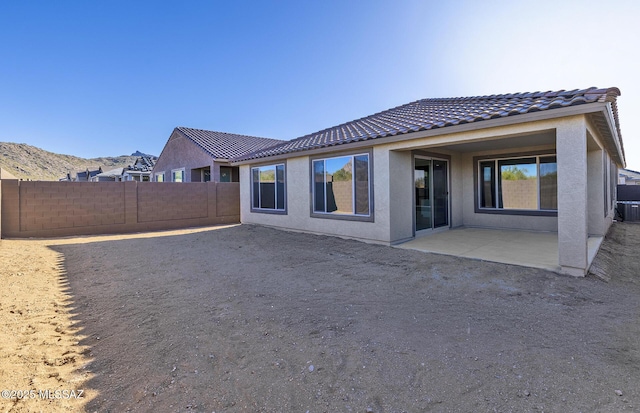 rear view of house featuring a mountain view and a patio area