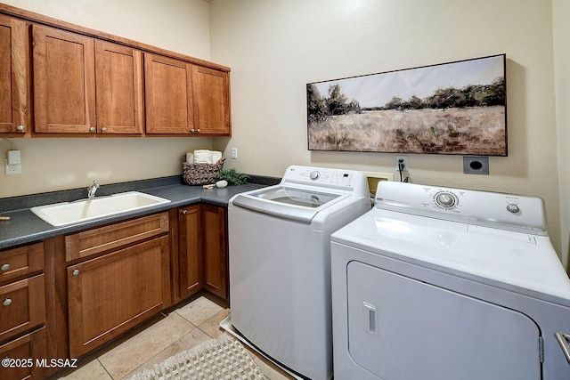 laundry room with sink, light tile patterned floors, washer and clothes dryer, and cabinets