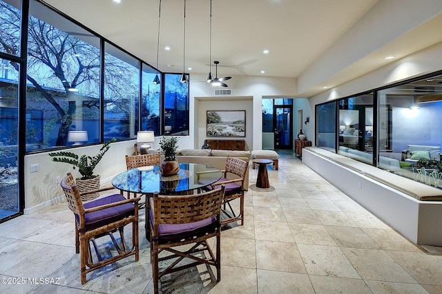 dining area with floor to ceiling windows and ceiling fan