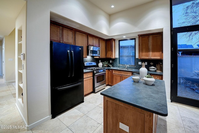 kitchen featuring sink, a kitchen island, stainless steel appliances, decorative backsplash, and a high ceiling