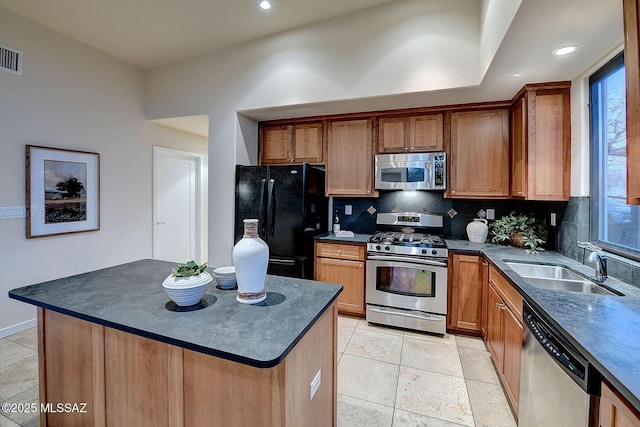 kitchen featuring a kitchen island, appliances with stainless steel finishes, sink, and decorative backsplash