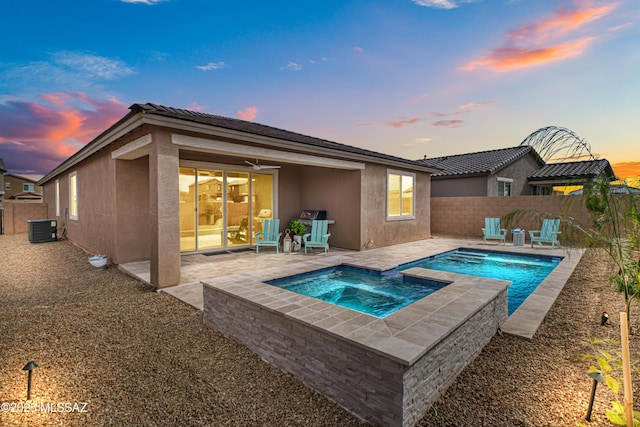 pool at dusk featuring central AC, a patio, a fenced backyard, and a pool with connected hot tub