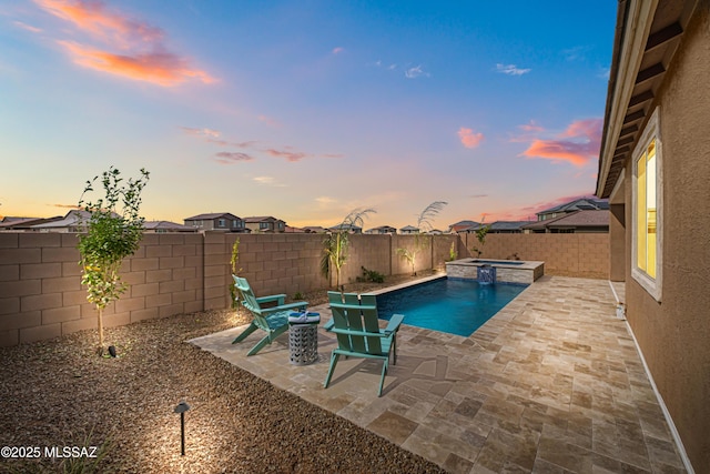 view of swimming pool featuring a pool with connected hot tub, a patio area, and a fenced backyard