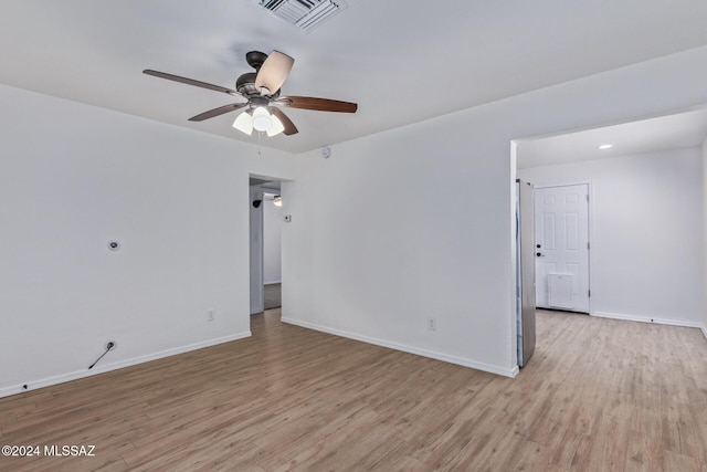 empty room with ceiling fan and light hardwood / wood-style flooring