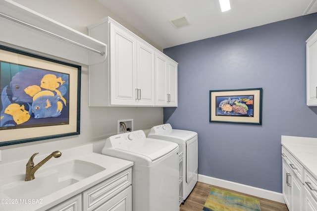 2333 E Copper Valley Way, Green Valley, AZ 85614 - clothes washing area with wood finished floors, cabinet space, a sink, visible vents, and washer and clothes dryer