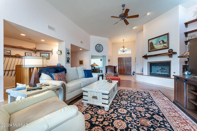 living room featuring ceiling fan with notable chandelier and high vaulted ceiling