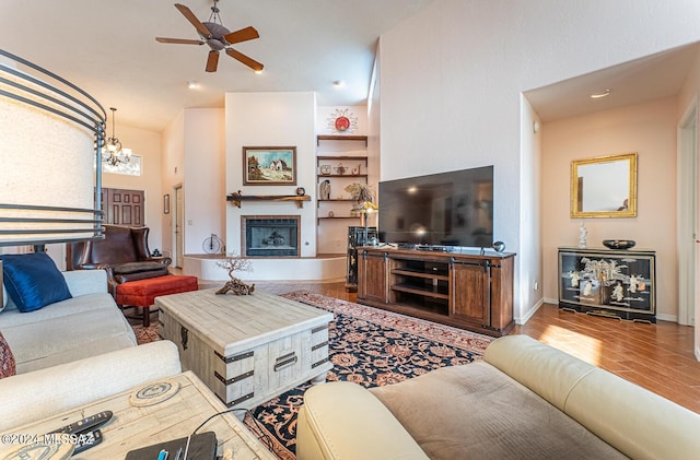 living room featuring hardwood / wood-style flooring and ceiling fan with notable chandelier