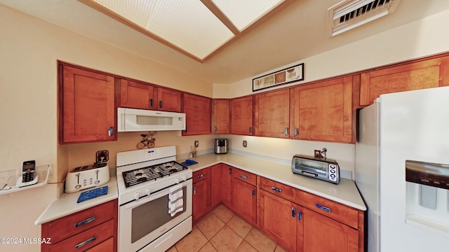 kitchen with light tile patterned floors and white appliances