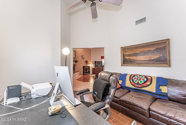 living room with ceiling fan and a high ceiling