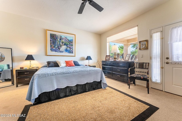 bedroom featuring a textured ceiling, light colored carpet, and ceiling fan