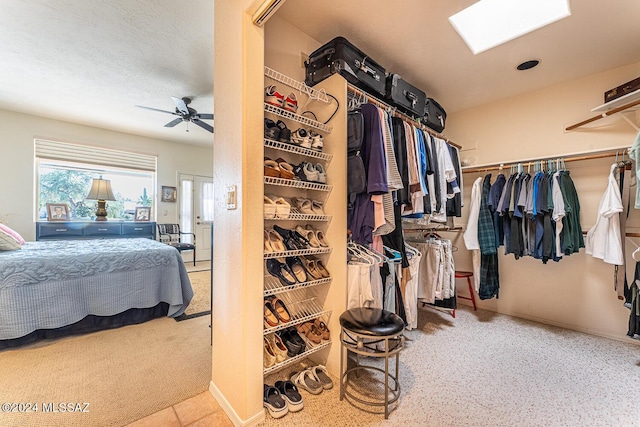 walk in closet featuring ceiling fan and a skylight