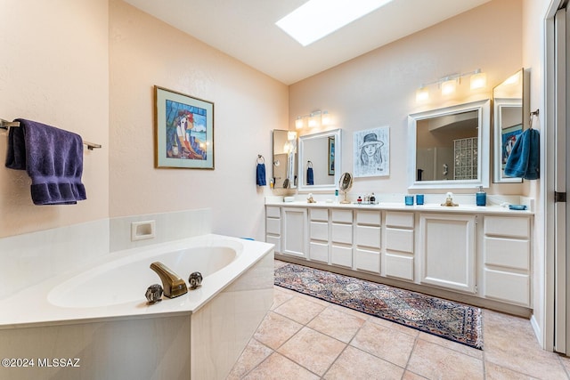 bathroom with vanity, a relaxing tiled tub, tile patterned floors, and a skylight