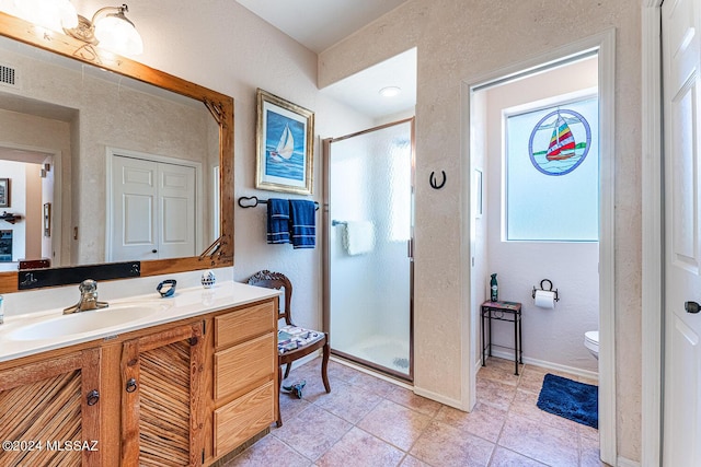 bathroom featuring walk in shower, vanity, toilet, and tile patterned flooring