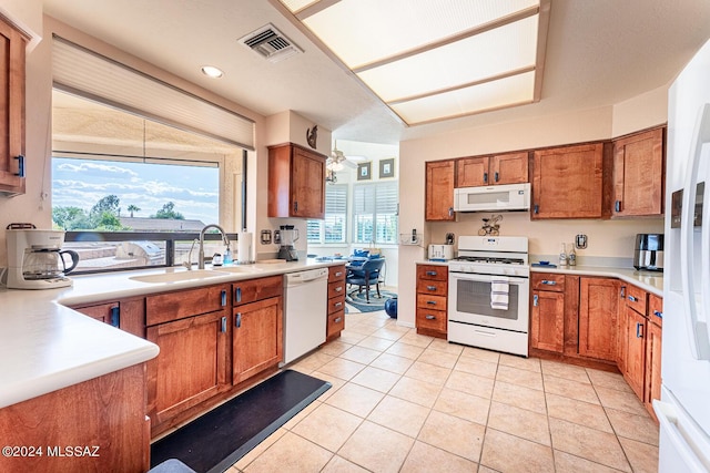 kitchen with white appliances, sink, and light tile patterned floors