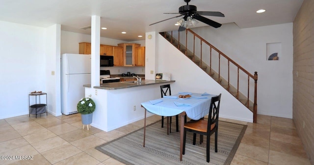 kitchen featuring kitchen peninsula, ceiling fan, sink, black appliances, and light tile patterned floors