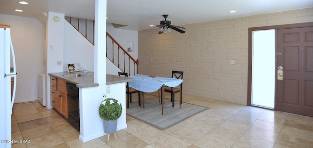 interior space featuring ceiling fan, sink, light tile patterned flooring, and brick wall