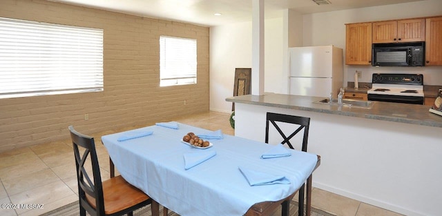 tiled dining space with sink and brick wall