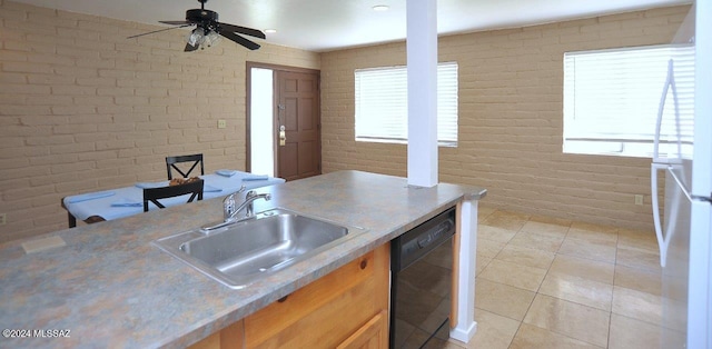 kitchen featuring sink, a healthy amount of sunlight, black dishwasher, brick wall, and light tile patterned floors