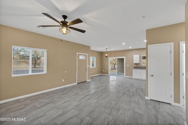 unfurnished living room with ceiling fan