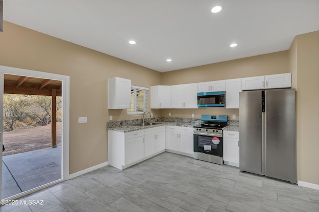 kitchen featuring light stone countertops, sink, white cabinets, and stainless steel appliances