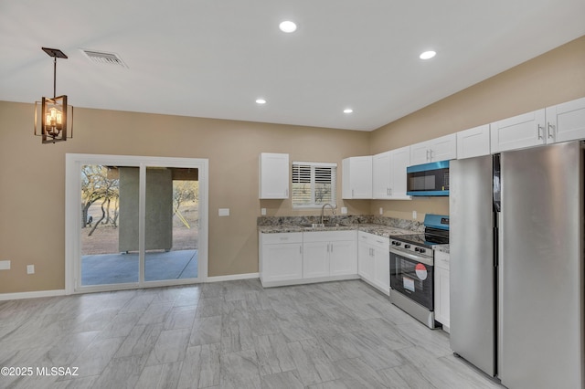 kitchen with light stone countertops, a wealth of natural light, stainless steel appliances, sink, and white cabinetry