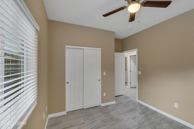 unfurnished bedroom with ceiling fan and a closet