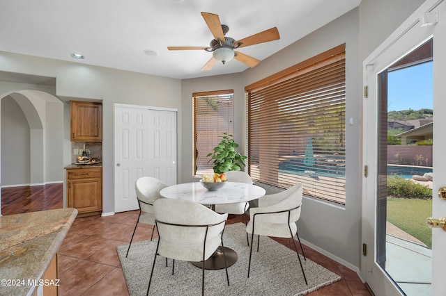 tiled dining room featuring plenty of natural light and ceiling fan