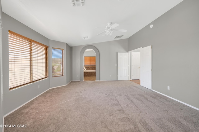 unfurnished bedroom with light carpet, ensuite bathroom, and ceiling fan