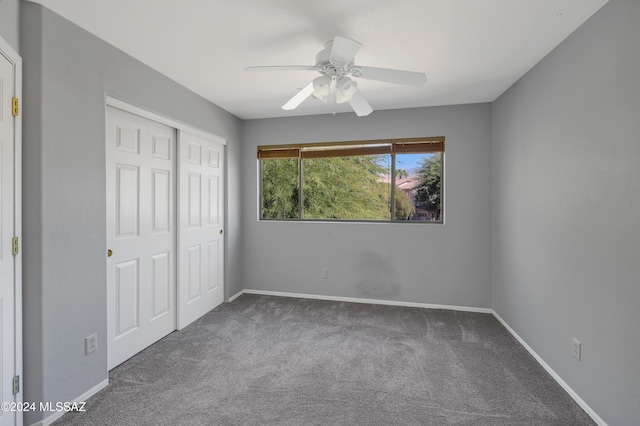 unfurnished bedroom featuring ceiling fan, a closet, and carpet floors