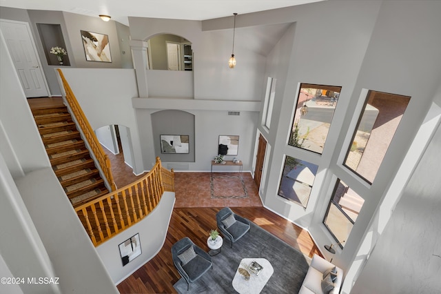 entrance foyer with dark hardwood / wood-style flooring and a towering ceiling