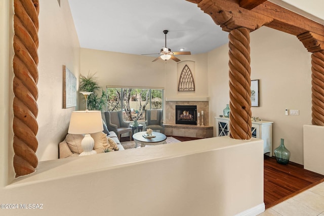 living area featuring tile patterned flooring, a fireplace, and a ceiling fan