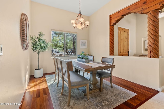 dining area featuring a notable chandelier, baseboards, and hardwood / wood-style flooring