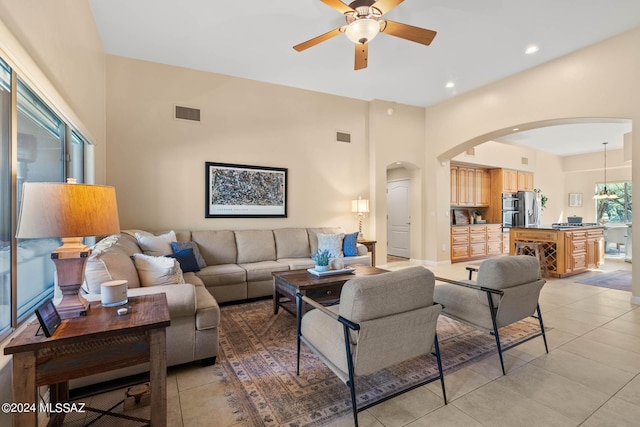 tiled living room with a high ceiling and ceiling fan