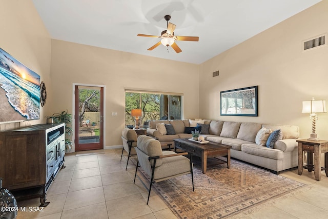 living room with a high ceiling, ceiling fan, and light tile patterned floors