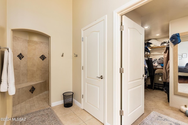 bathroom featuring tile patterned flooring and a tile shower