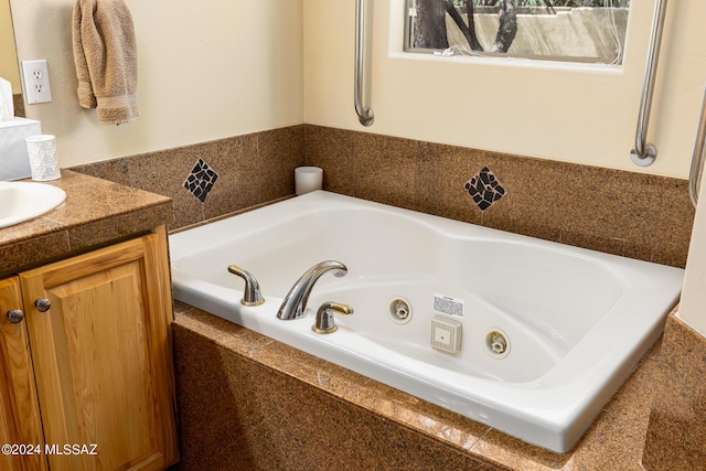 full bathroom with a tub with jets and vanity