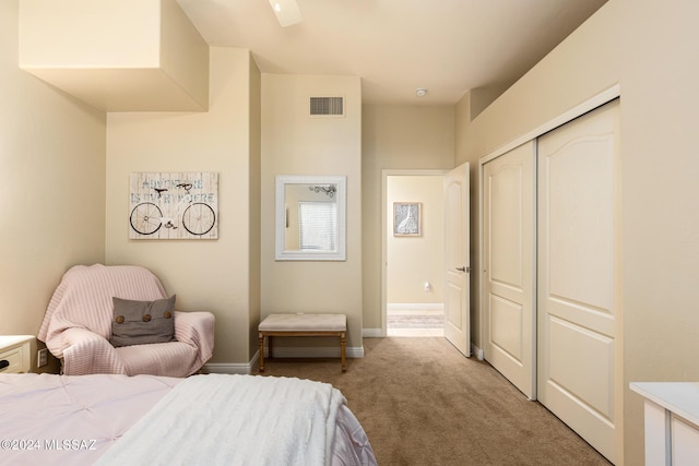 carpeted bedroom with ceiling fan and a closet