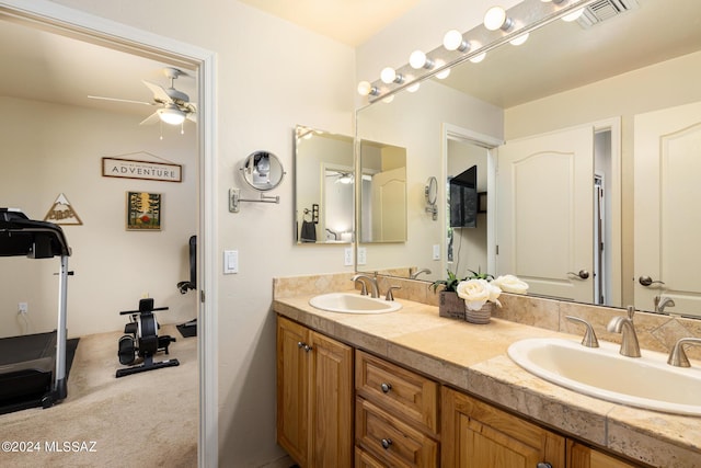 full bath with double vanity, visible vents, ceiling fan, and a sink