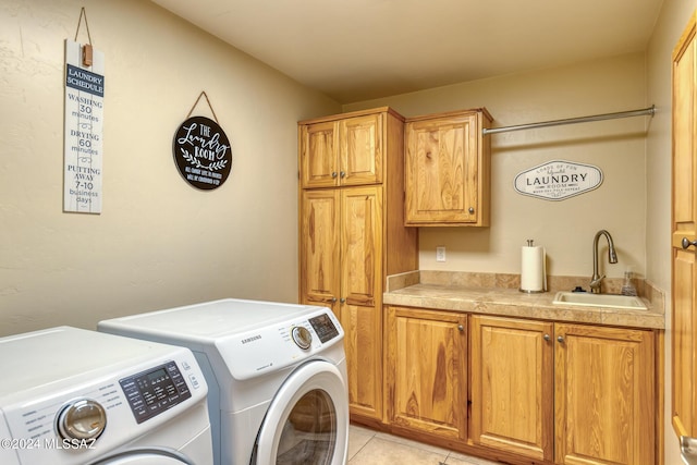 laundry area with cabinets, washing machine and dryer, light tile patterned flooring, and sink