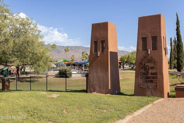 view of home's community with a lawn, a mountain view, and a playground