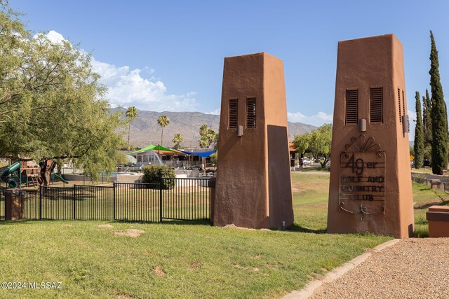 exterior space with a mountain view, fence, and a lawn