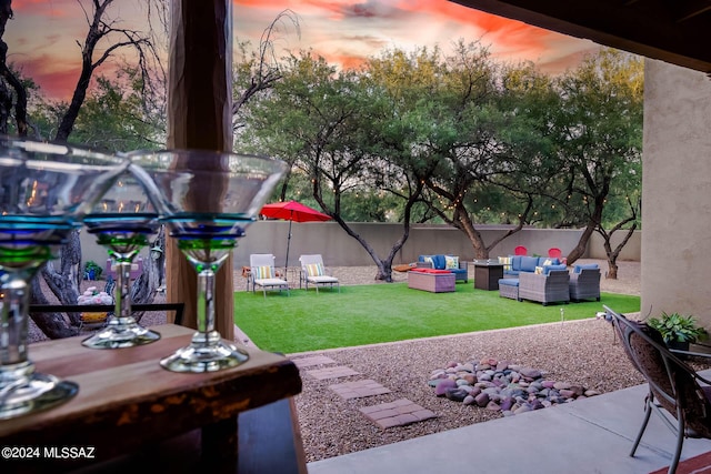 yard at dusk featuring a patio and an outdoor hangout area